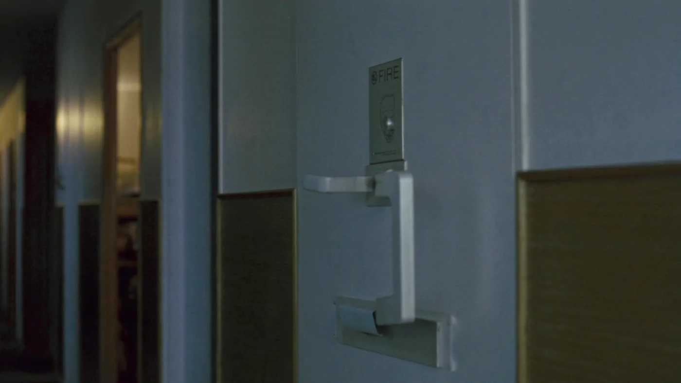 A fire door with an inspection tag in the corridor of a housing block