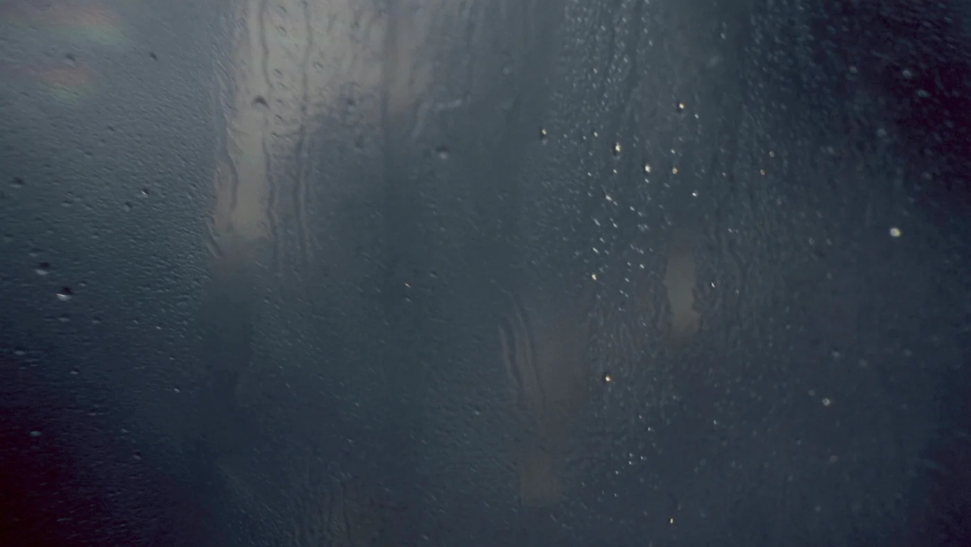 Condensation beading and running down a single-glazed sash window in a terraced house at dawn