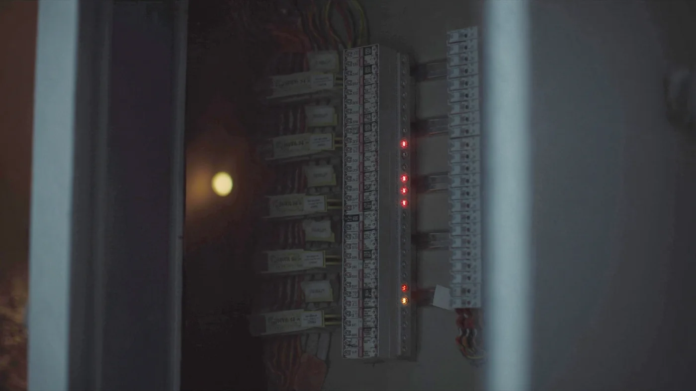 A half-open electrical distribution board with breakers and labelled circuits