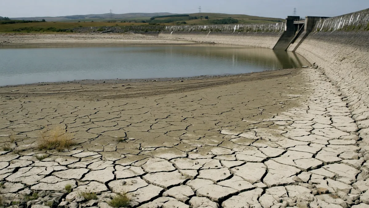 The cracked dry bed of a reservoir in drought with the water far down